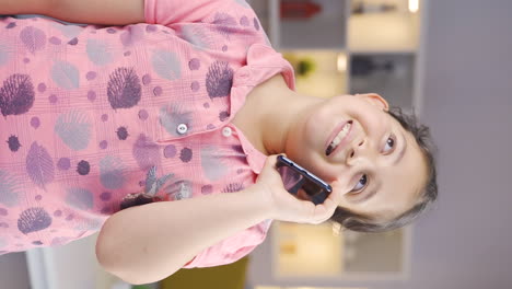 Vertical-video-of-Happy-talking-girl-child-on-the-phone.